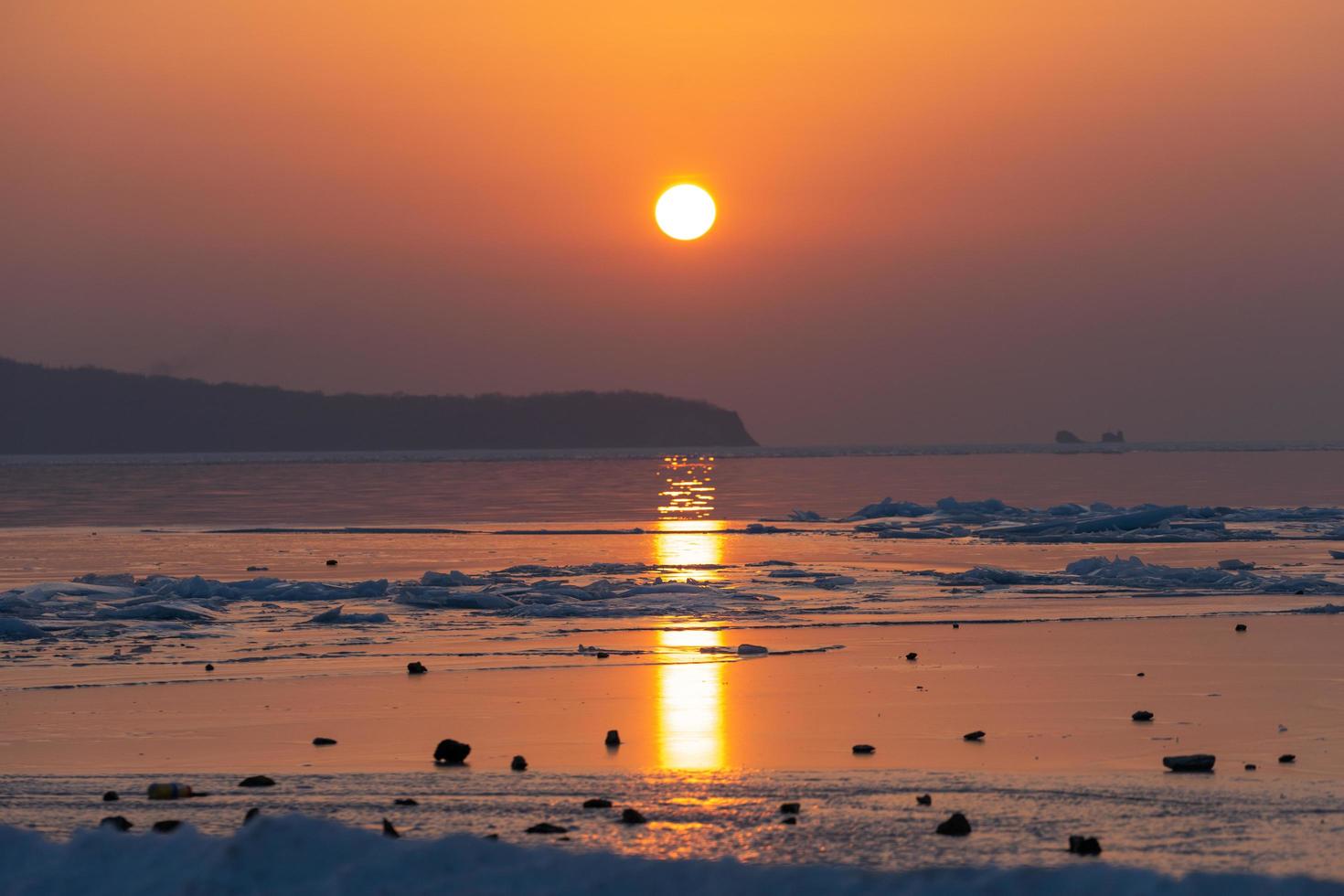 vista sul mare spiaggia di ghiaccio e il tramonto rosso. foto