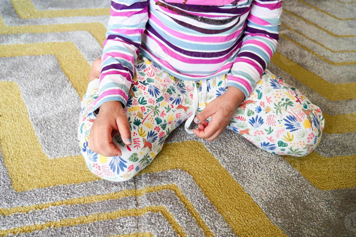 bambino seduta w posizione su il pavimento . foto