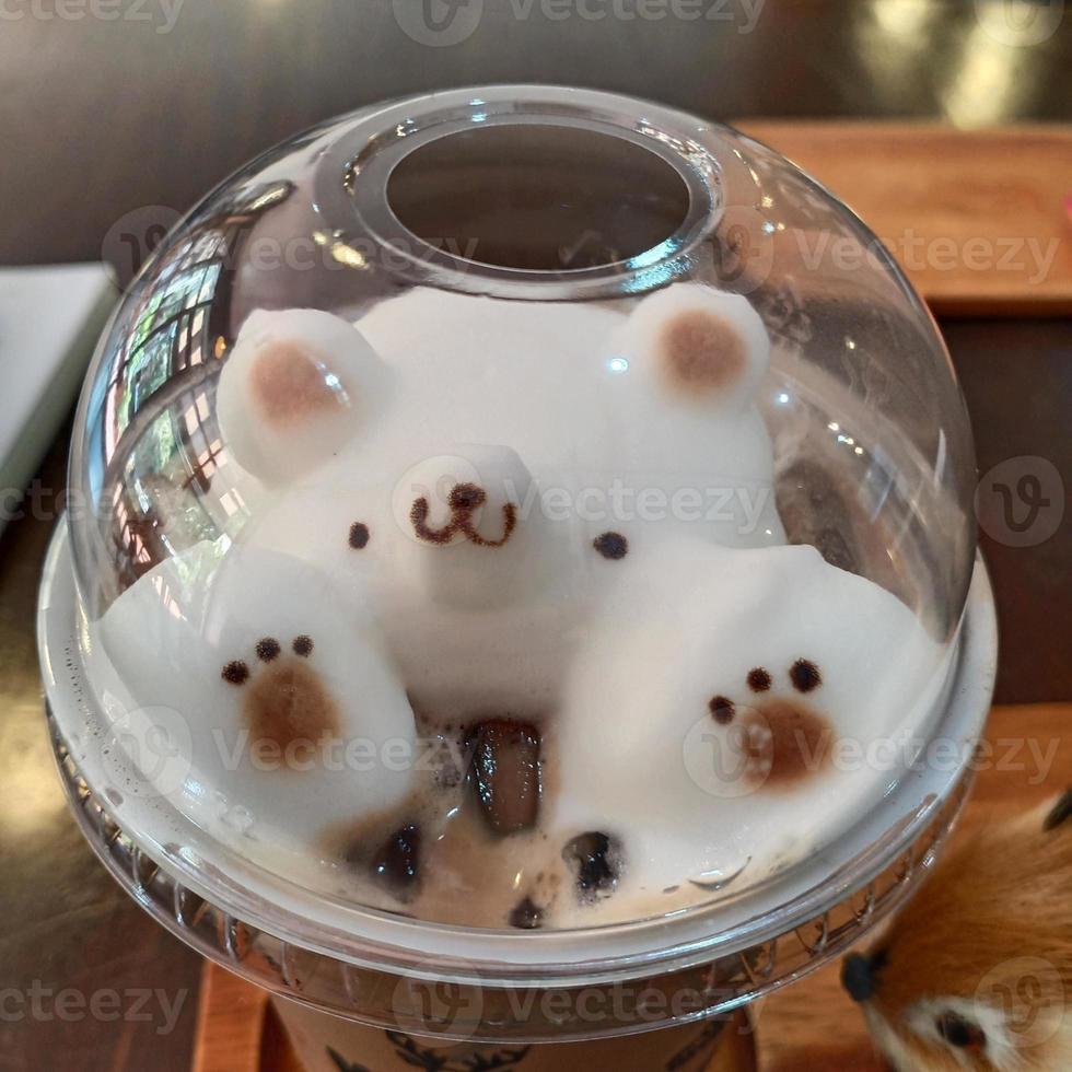 latte schiuma nel orso forma guarnizione su ghiaccio caffè sotto plastica bicchiere coperchio. foto