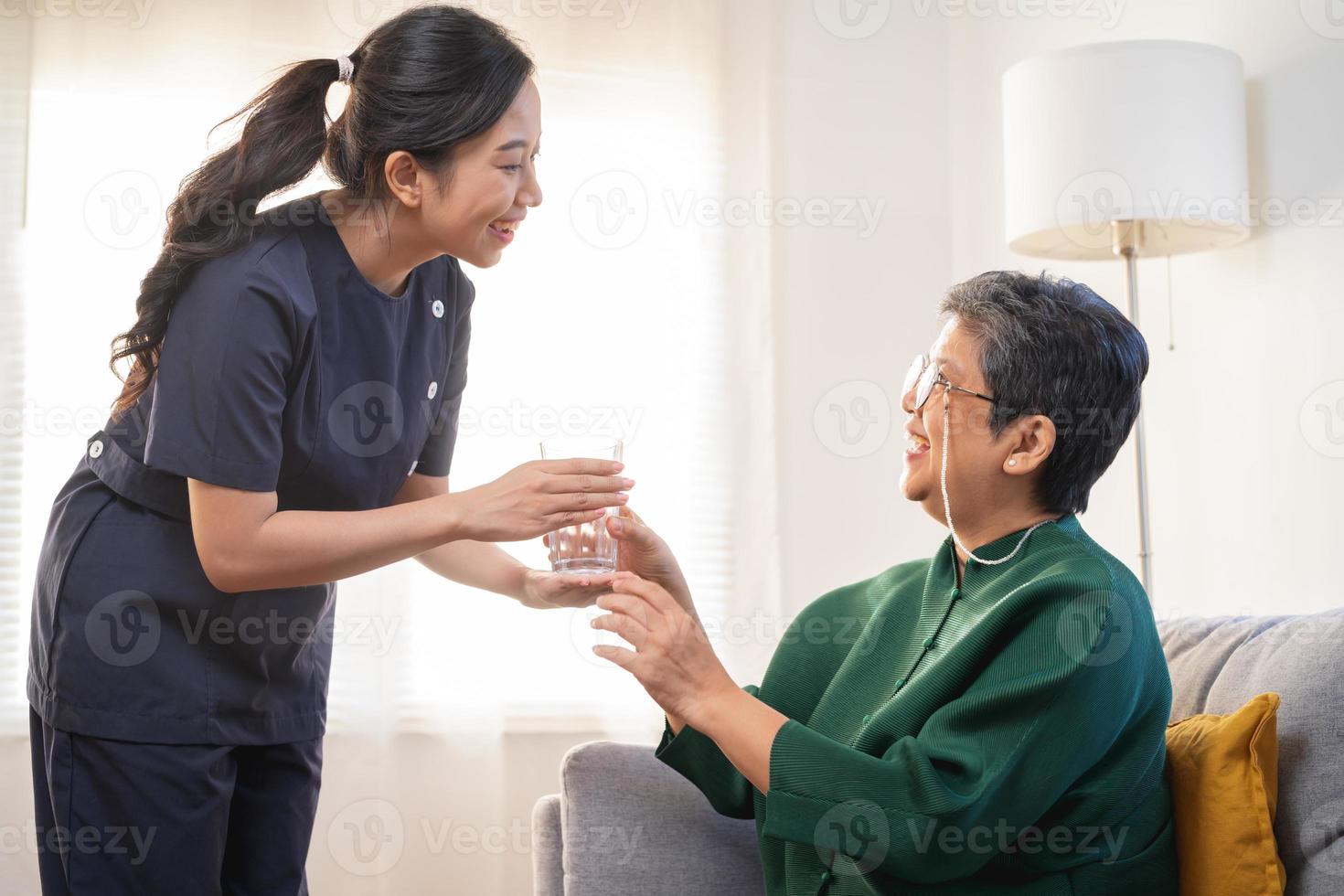 asiatico giovane donna Caregiver, badante supporto anziano, anziano paziente a casa, potabile acqua dopo prendere medicinale, cura o trattamento malattia di nonna dopo la pensione, Aiuto sostegno. foto