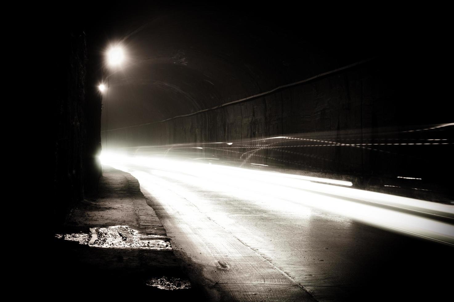 un tunnel buio con scie luminose foto