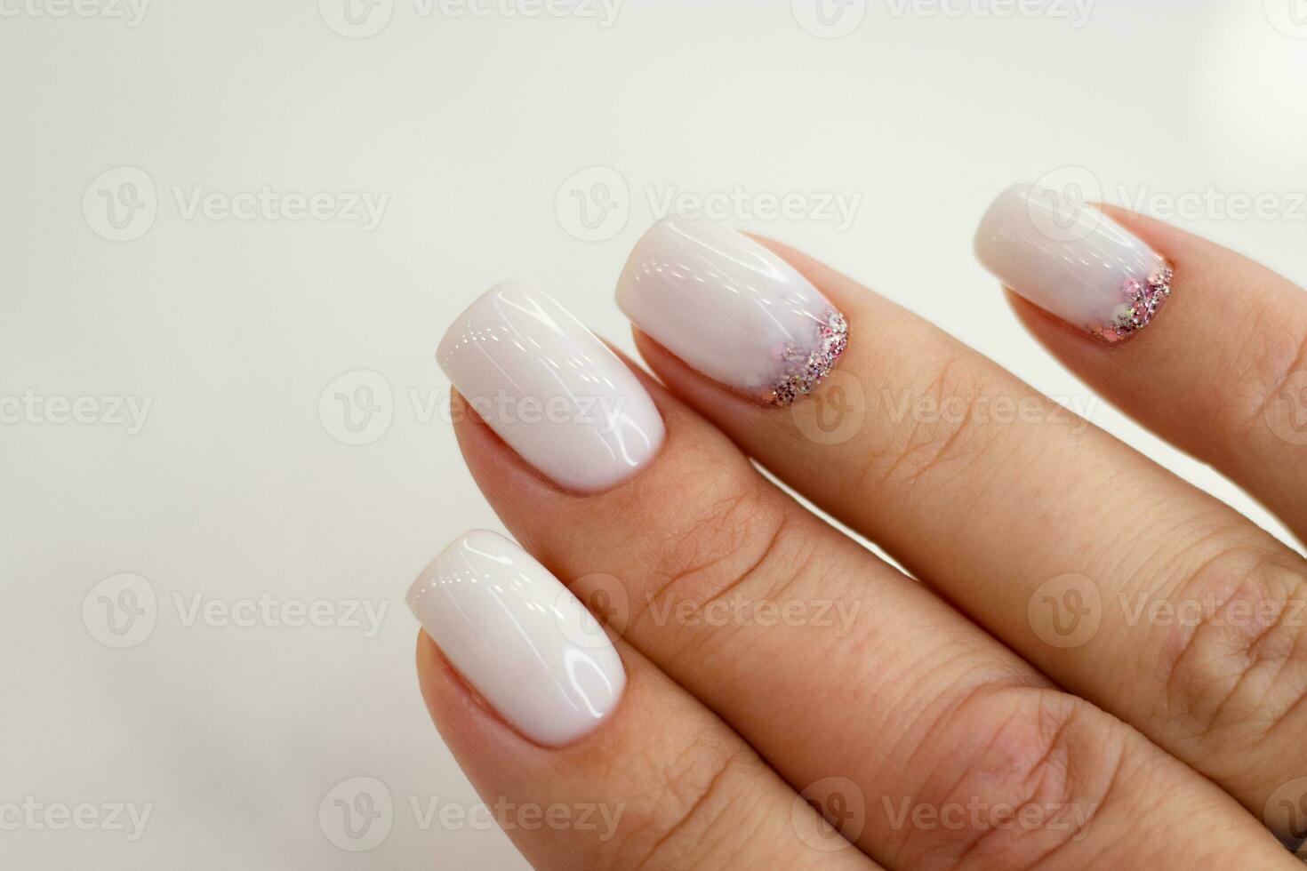 bellissimo nudo manicure. luccichio design. manicure per donne con gel polacco. corto Chiodi piazza latteo colore con luccichio foto