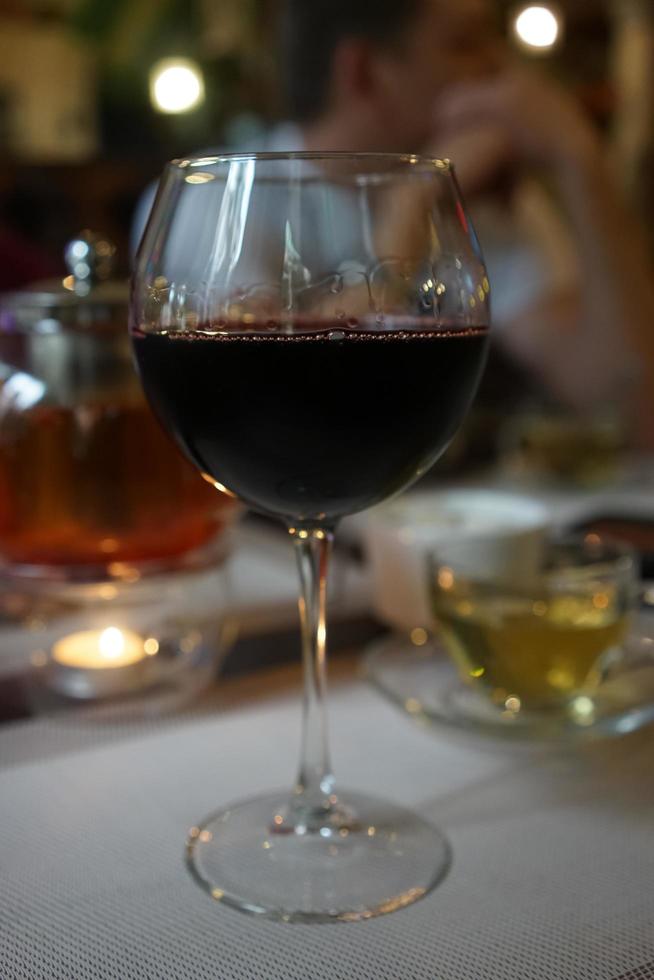un bicchiere di vino su uno sfondo sfocato con le persone. foto