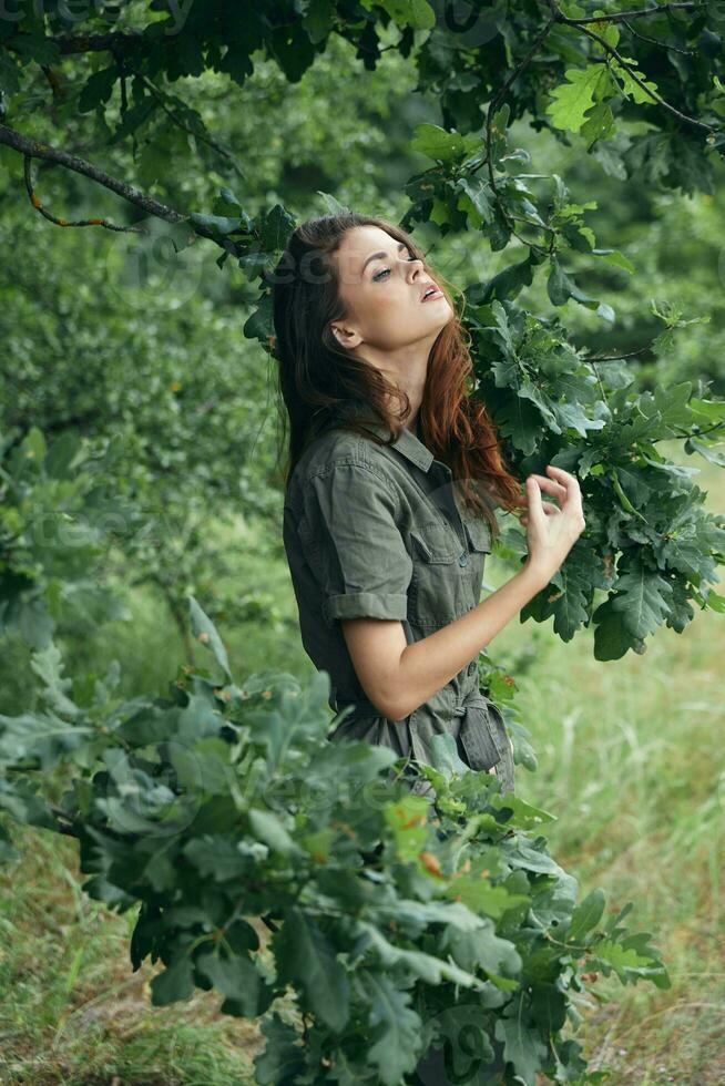 donna all'aperto verde ramo godendo natura alberi foto