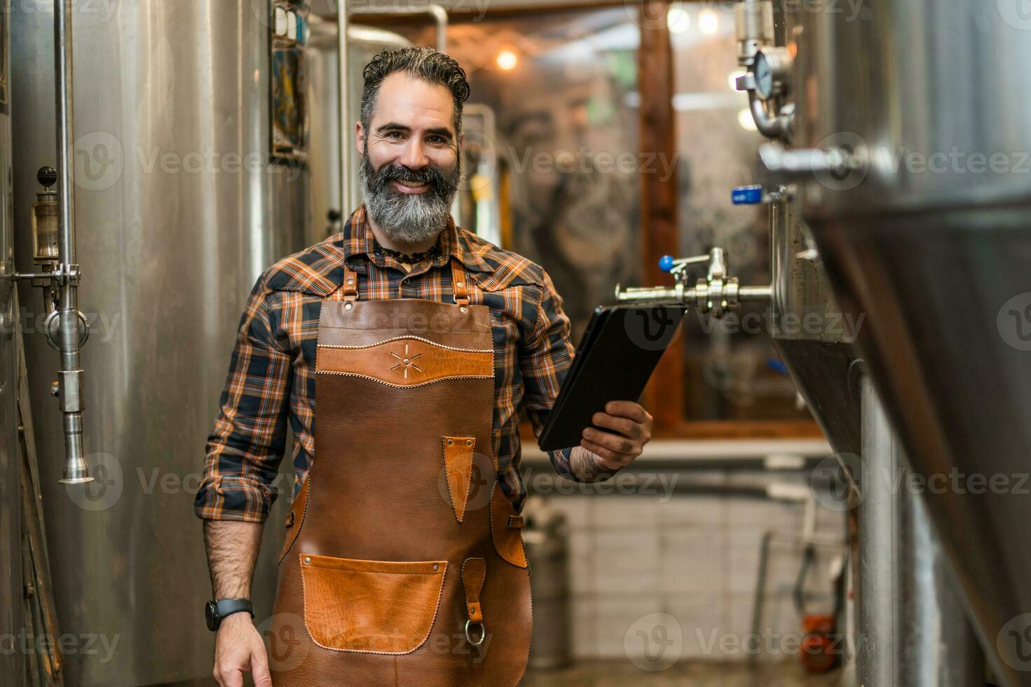 uomo è Lavorando a mestiere birra fabbrica. lui è operativo macchinari nel birrificio. piccolo famiglia attività commerciale, produzione di mestiere birra. foto