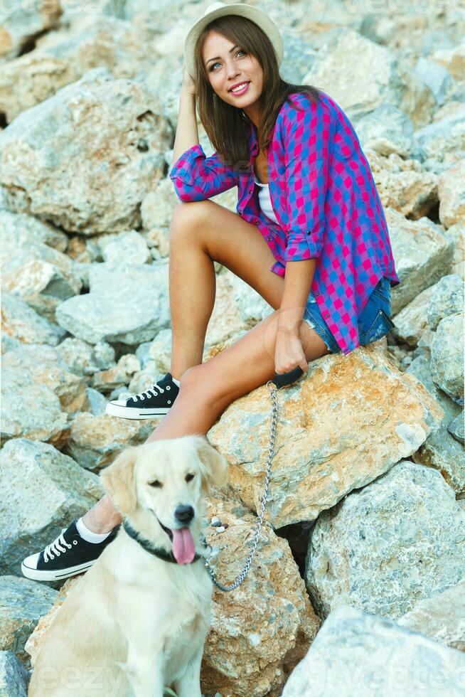 donna con un' cane su un' camminare su il spiaggia foto