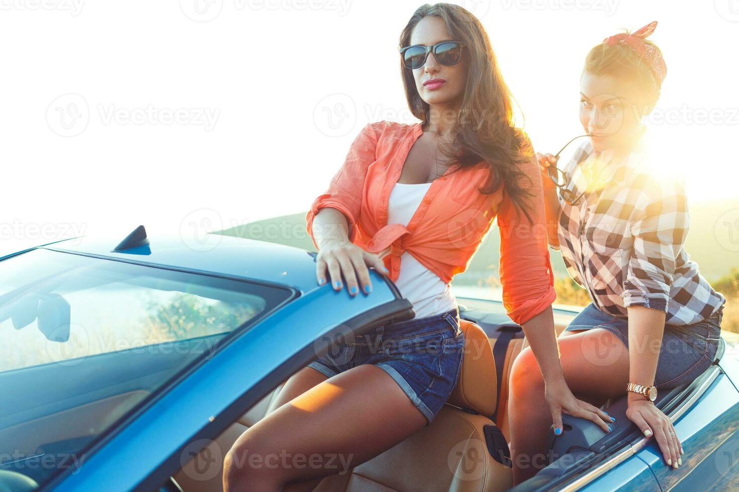Due giovane contento ragazze avendo divertimento nel il cabriolet all'aperto foto