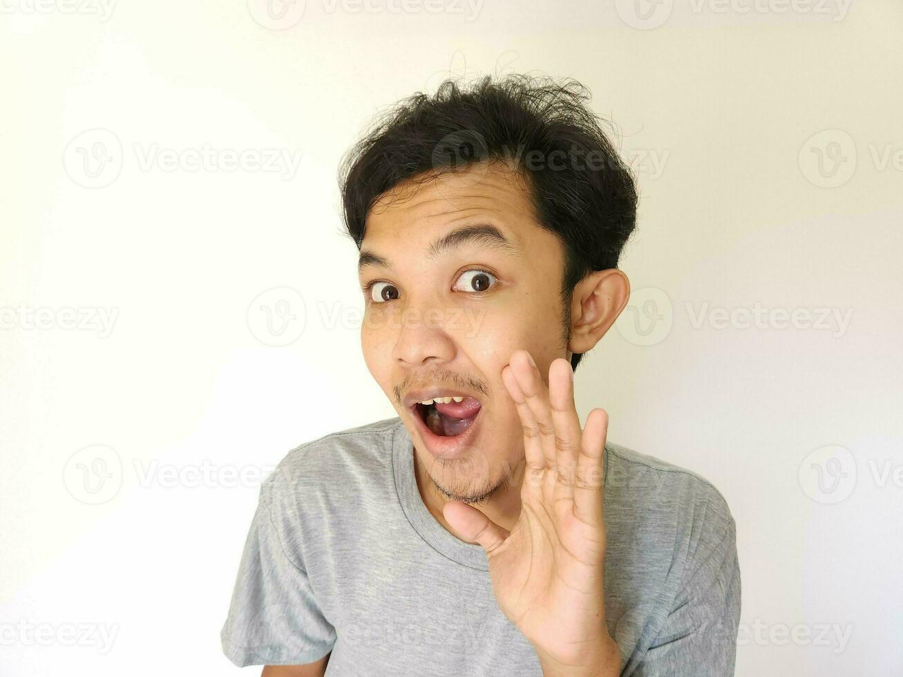 asiatico uomo è sussurrando alcuni segreto pettegolezzo isolato su bianca sfondo. foto