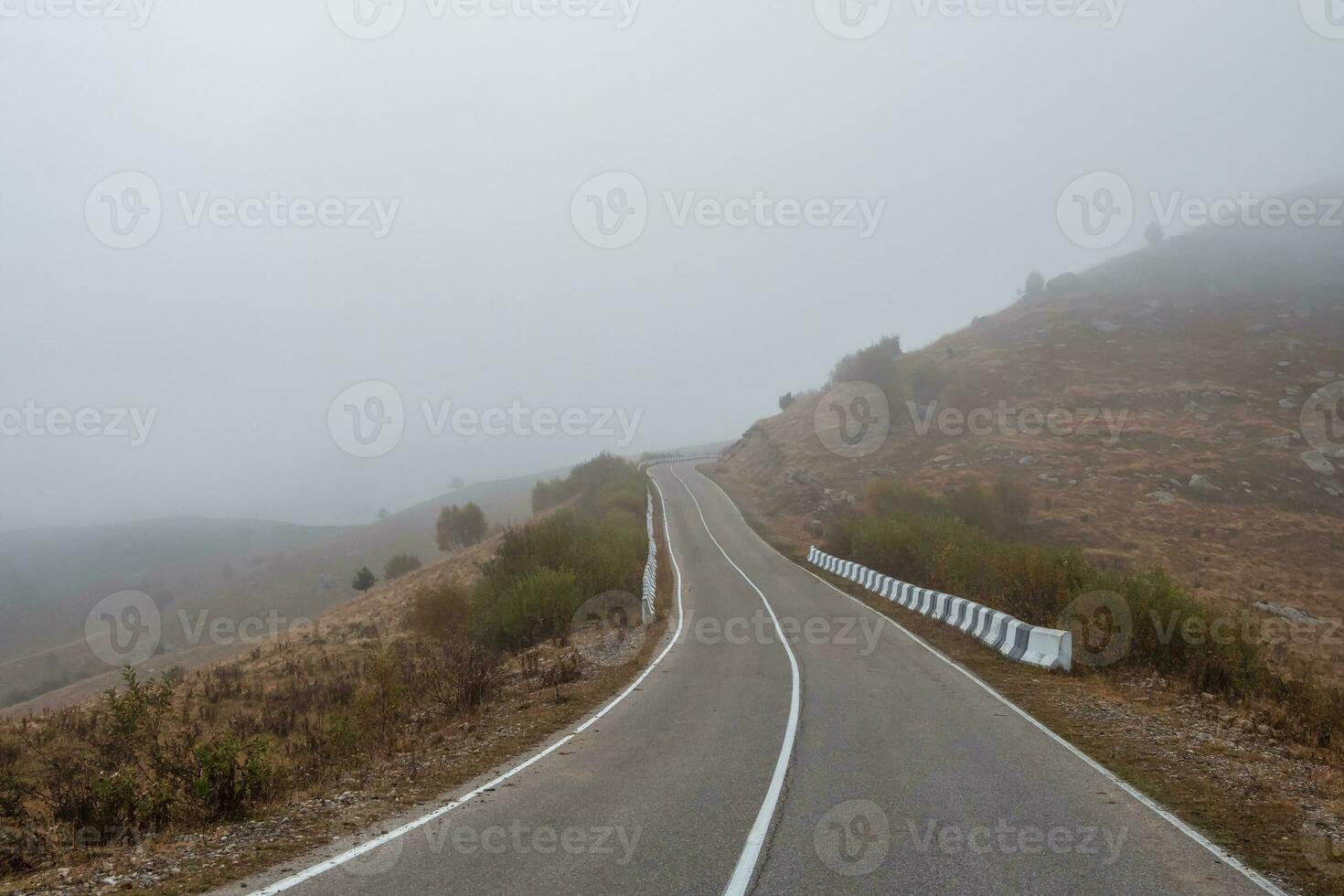vuoto mattina montagna autostrada nel un' denso nebbia. strada attraverso un' de foto