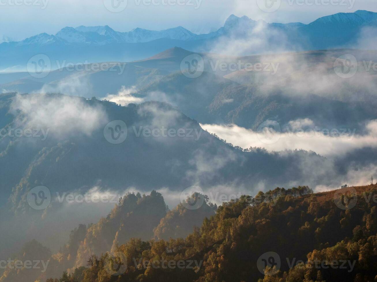 montagne nel un' denso nebbia e soleggiato pendenza. mistico paesaggio con bellissimo acuto rocce nel Basso nuvole. bellissimo montagna nebbioso scenario su abisso bordo con acuto foresta piste. sorprendente terra. foto