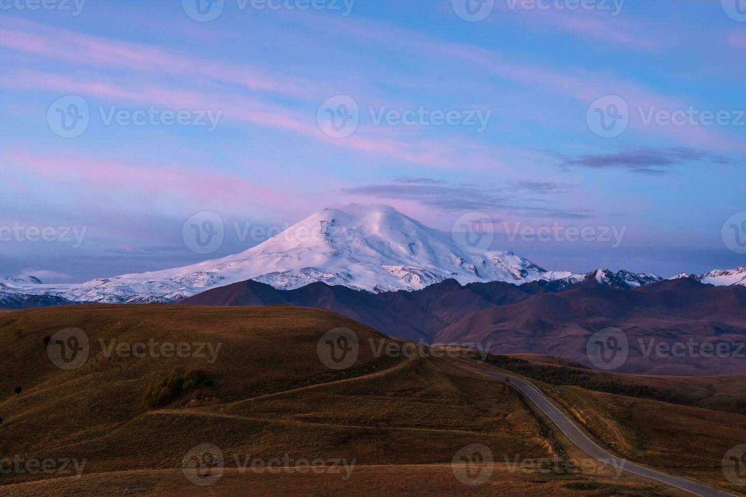 viola crepuscolo con snow-capped montagna superiore e autostrada attraverso autunno valle. foto