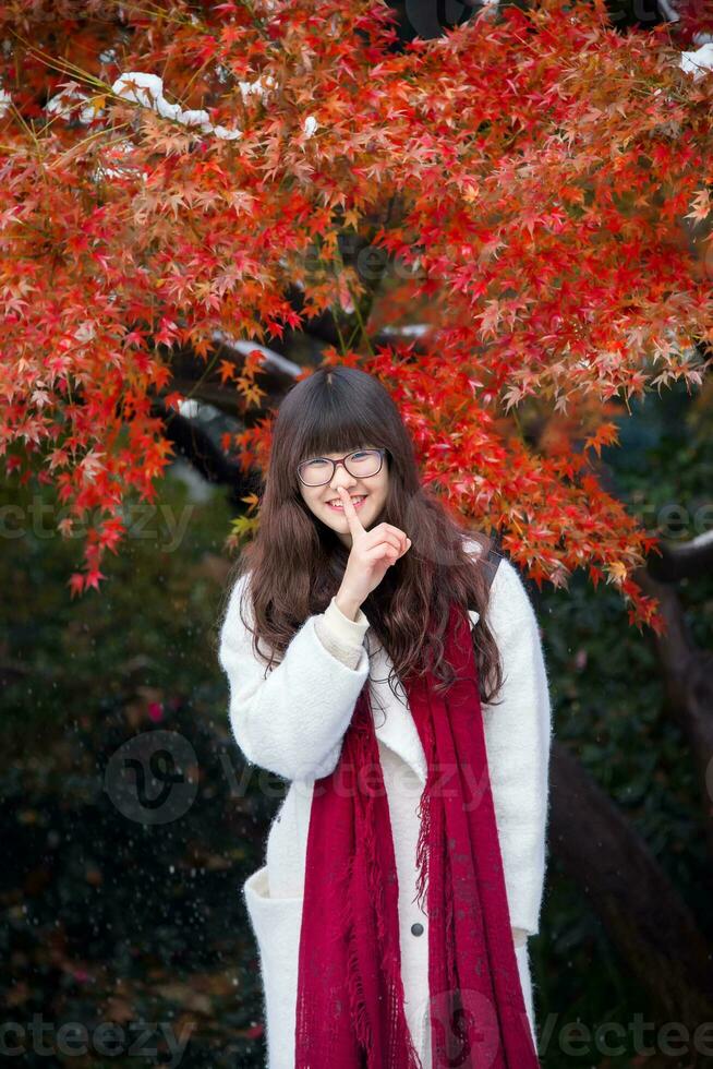 giovane Cinese donna nel azione con autunno le foglie foto