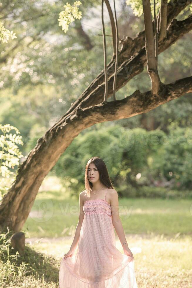 bella ragazza nel il parco con luce del sole giorno foto