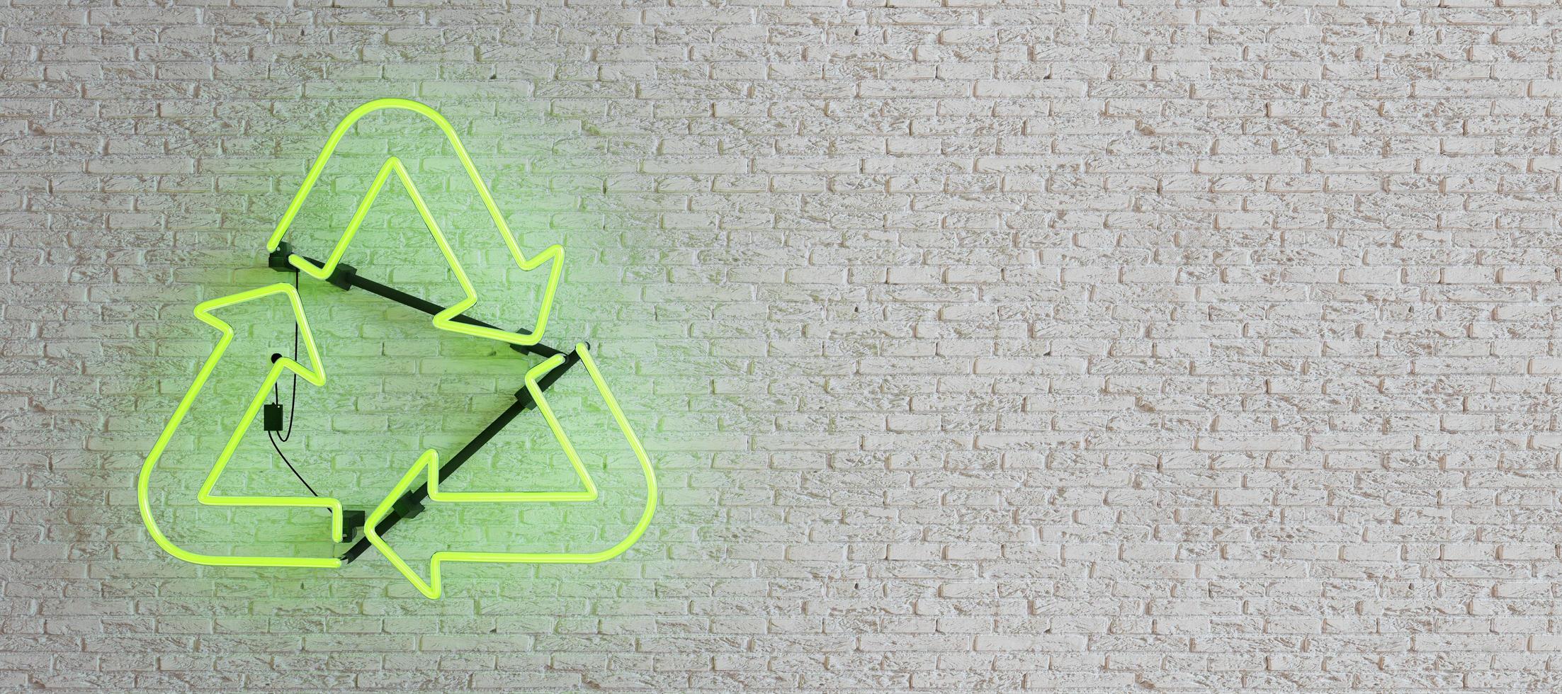 lampada al neon verde con simbolo di riciclaggio sul muro di mattoni bianchi foto