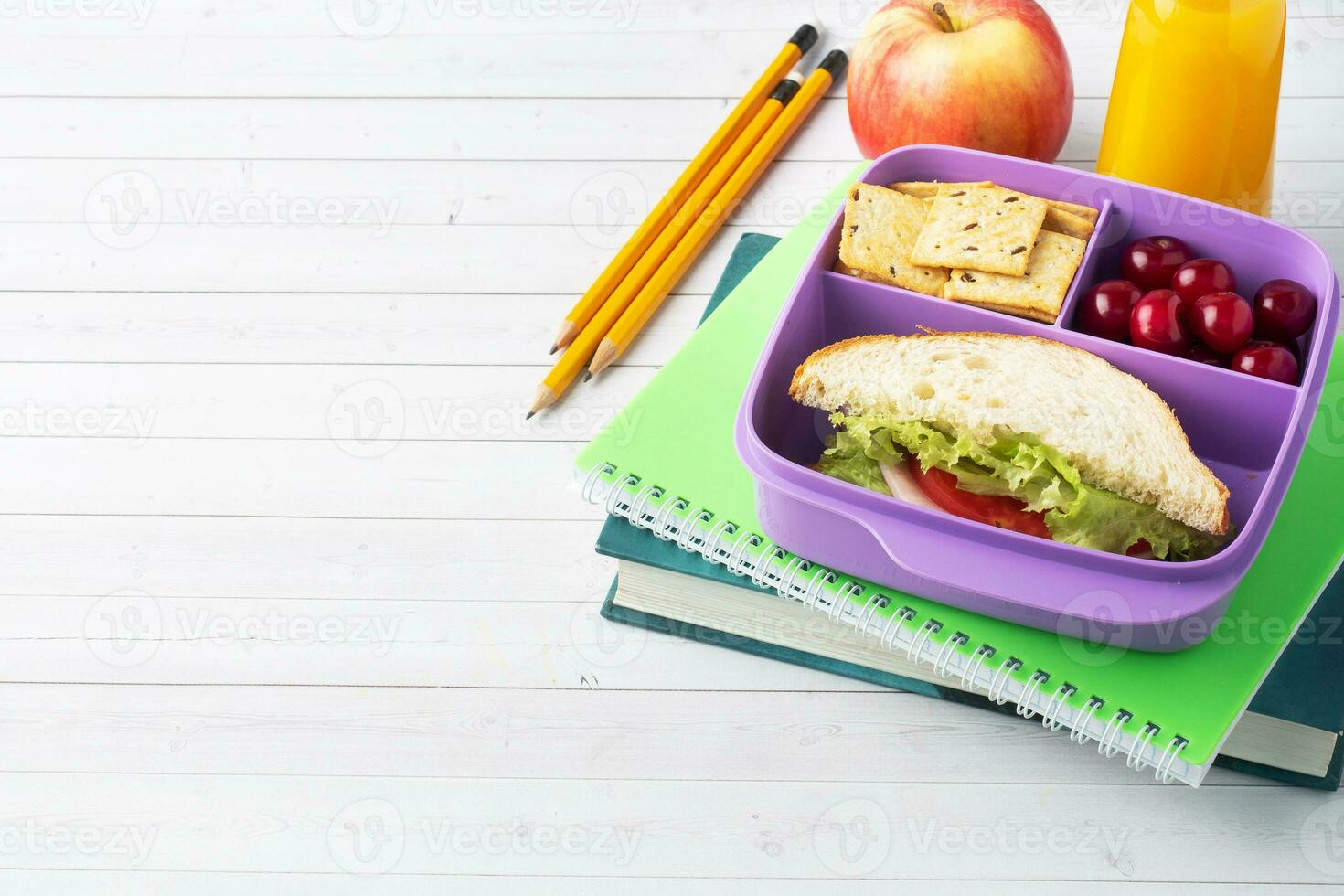 delizioso salutare Sandwich nel un' pranzo scatola, biscotti e ciliegie. prendere pranzo con voi per scuola o il ufficio. succo nel un' bottiglia e un Mela. foto