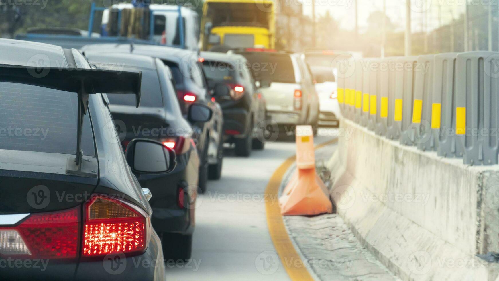 astratto per sfocato di macchine su il cemento strada. macchine parcheggiata nel un' lungo coda durante corsa ora. curvo calcestruzzo strada sentiero con strada guardie ✔ su il lati. foto