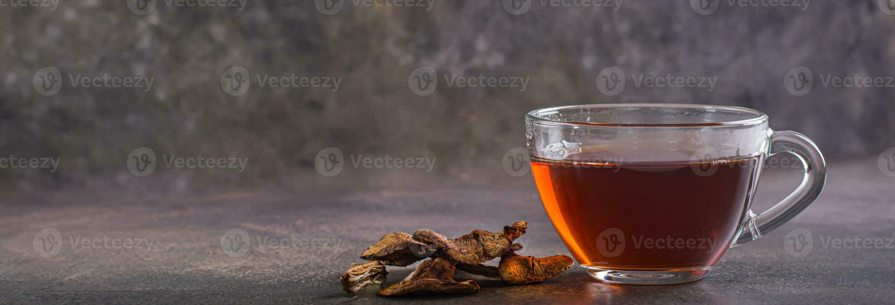 fatti in casa caldo tè a partire dal secco funghi nel un' tazza su il tavolo ragnatela bandiera foto