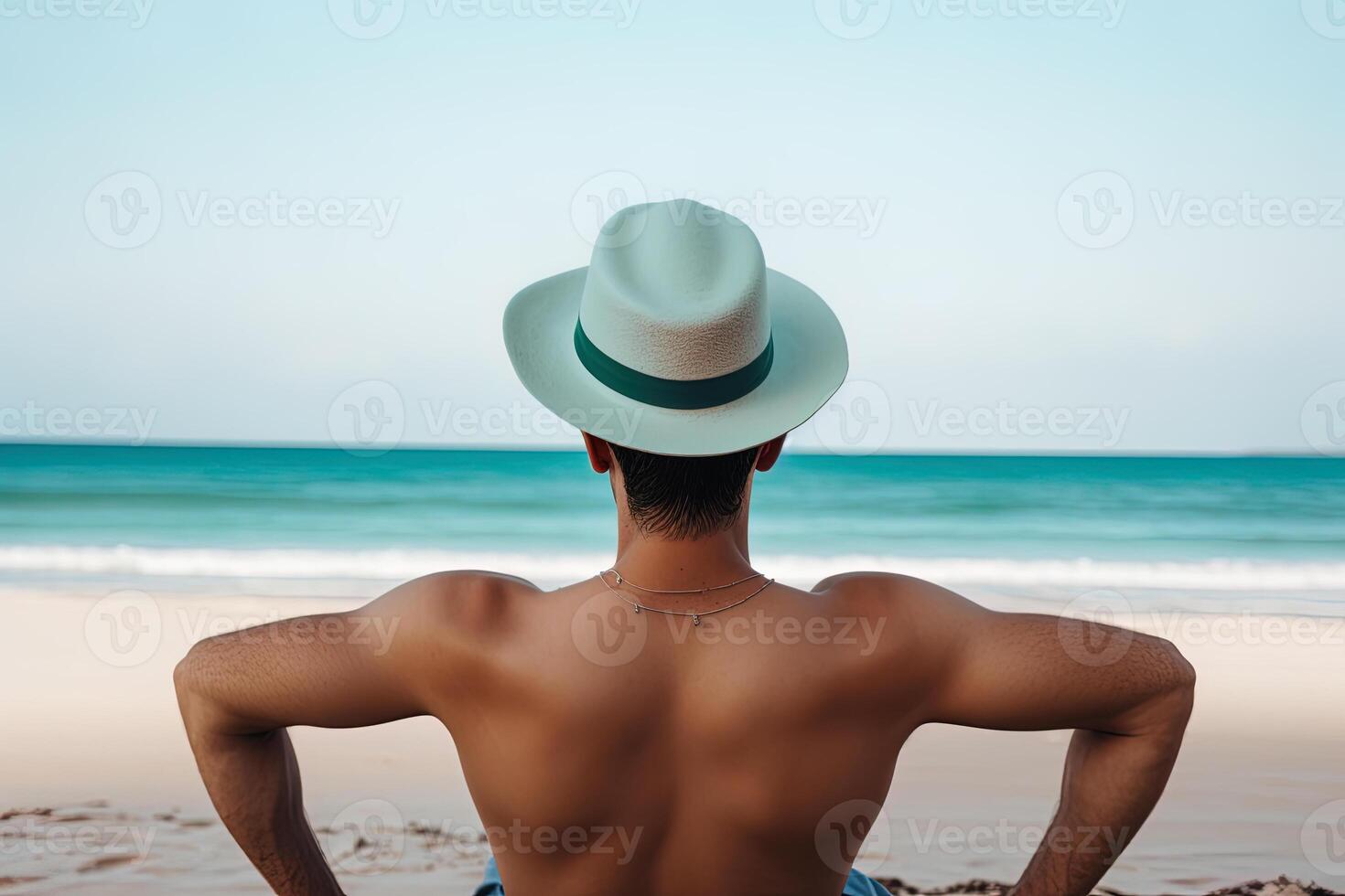 indietro Visualizza di un' uomo indossare un' cappello seduta su un' spiaggia. ai generato foto