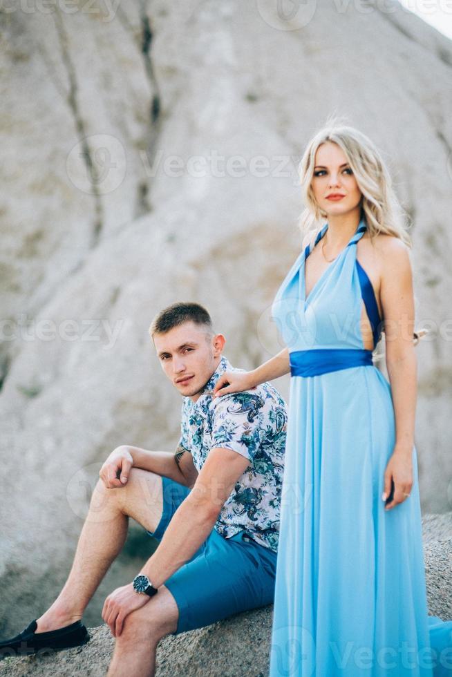 ragazza bionda in un vestito azzurro e un ragazzo in pantaloncini leggeri in una cava di granito foto