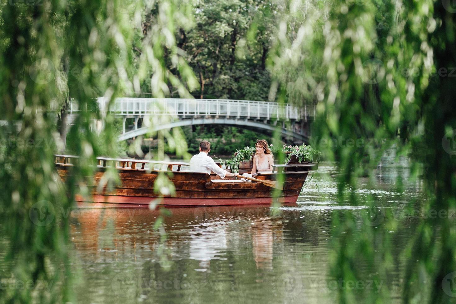 una gita in barca per un ragazzo e una ragazza lungo i canali e le baie del fiume foto