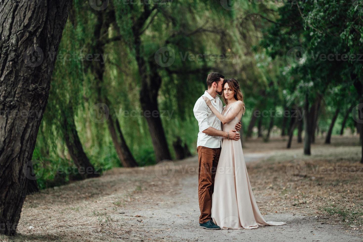 un ragazzo e una ragazza stanno camminando lungo le rive di un fiume selvaggio ricoperto di vegetazione foto