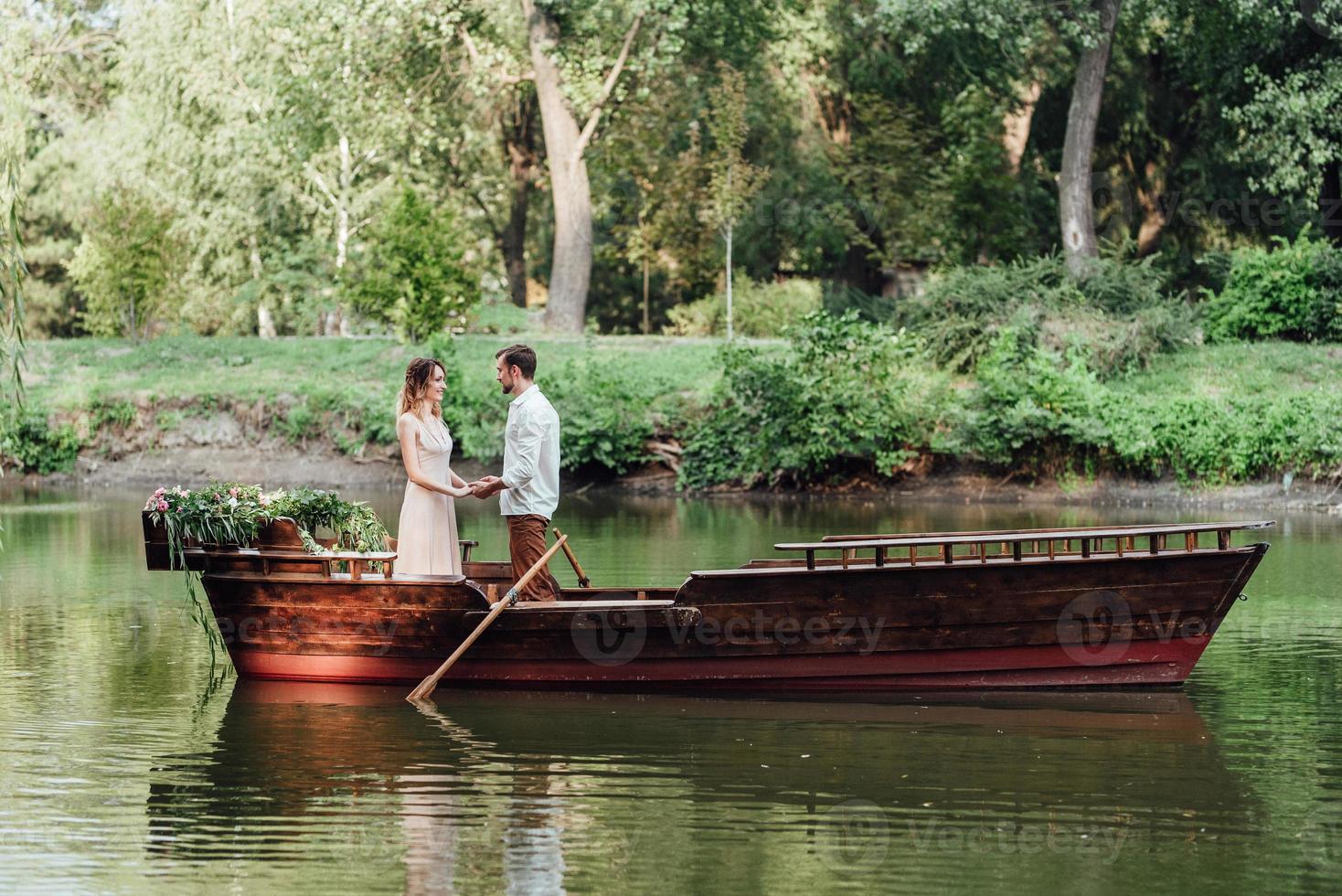 una gita in barca per un ragazzo e una ragazza lungo i canali e le baie del fiume foto