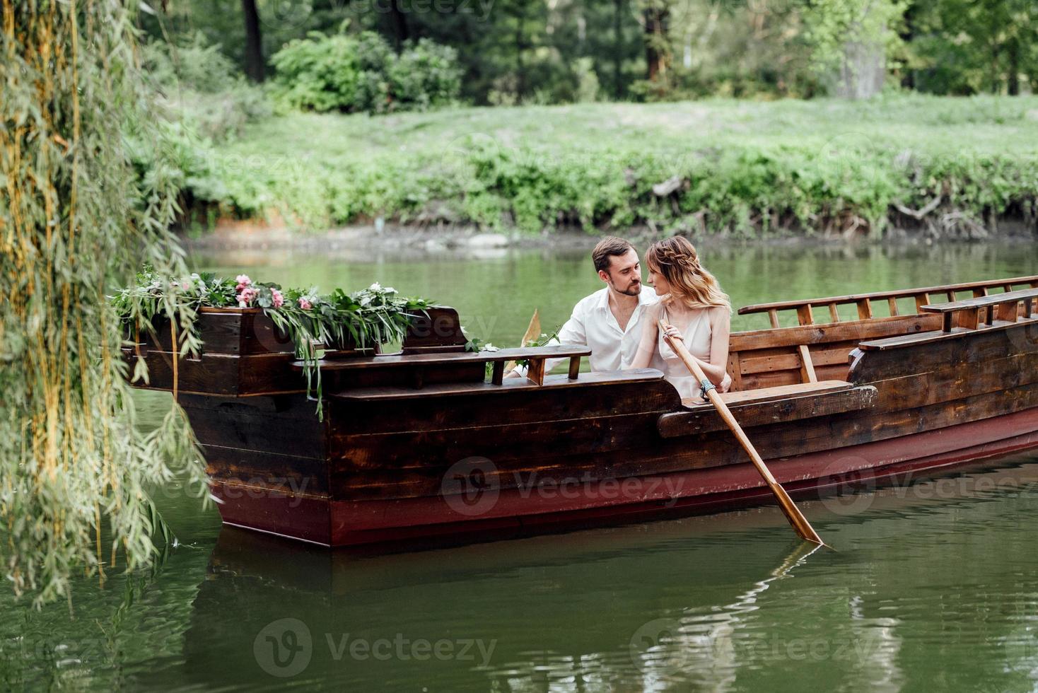 una gita in barca per un ragazzo e una ragazza lungo i canali e le baie del fiume foto