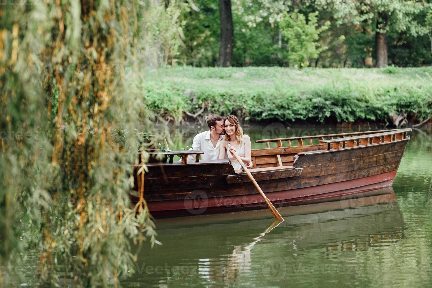 una gita in barca per un ragazzo e una ragazza lungo i canali e le baie del fiume foto