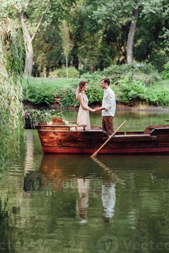 una gita in barca per un ragazzo e una ragazza lungo i canali e le baie del fiume foto