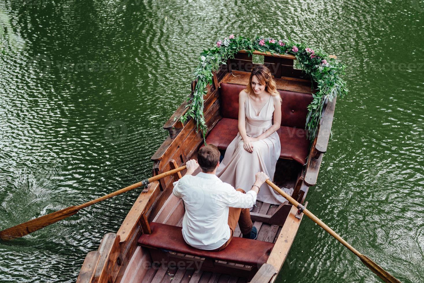 una gita in barca per un ragazzo e una ragazza lungo i canali e le baie del fiume foto