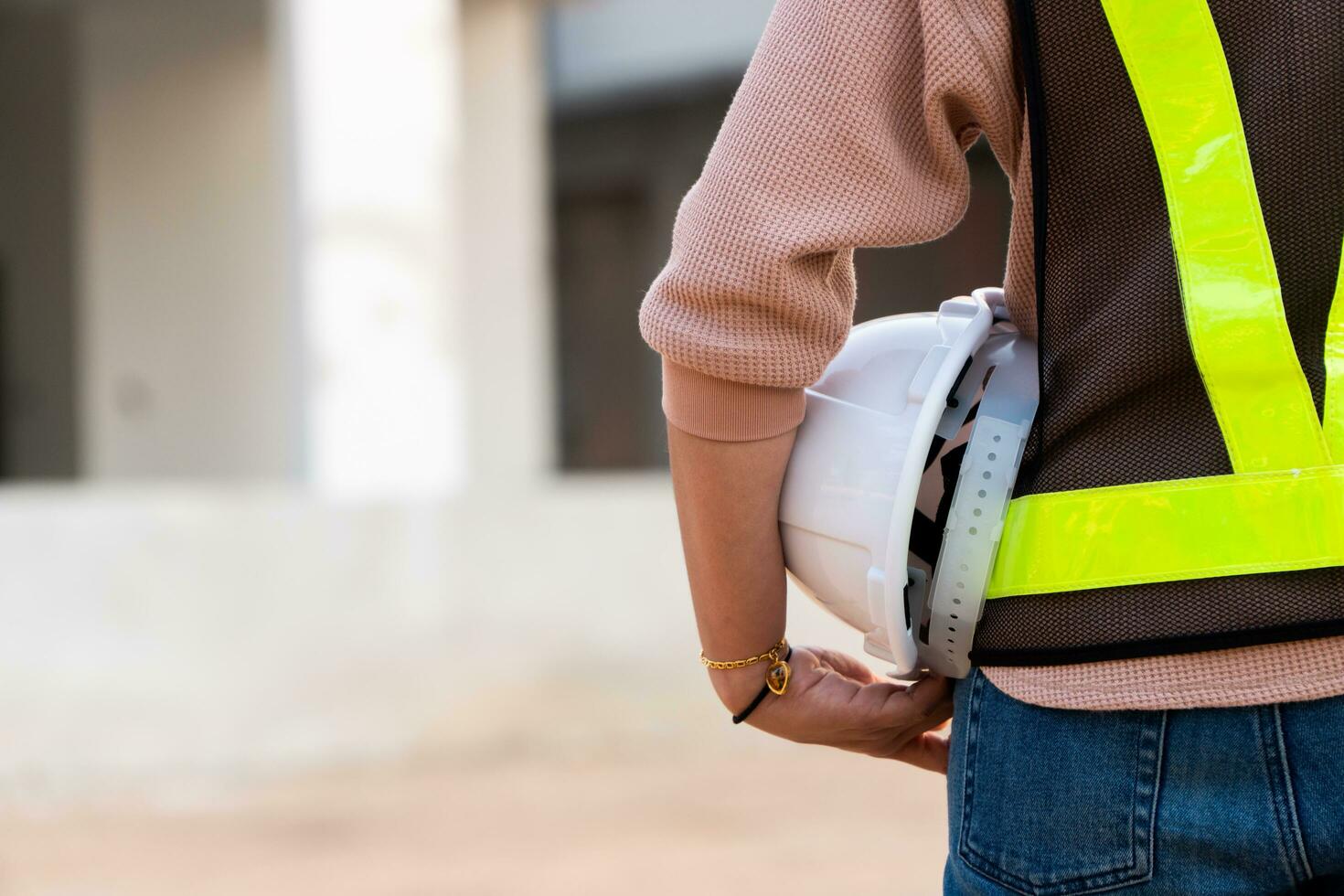 ritratto di un asiatico donna ingegnere costruzione lavoratore indossare un' casco utilizzando un' tavoletta mentre in piedi a un' costruzione luogo. edificio Posizione su il sfondo, concetto di uguaglianza e successo foto