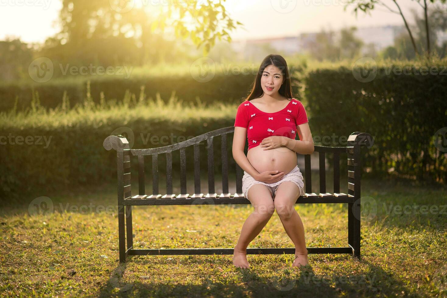 immagine di una donna incinta che si tocca il ventre con le mani foto