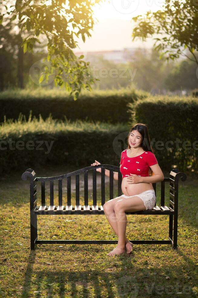 immagine di una donna incinta che si tocca il ventre con le mani foto