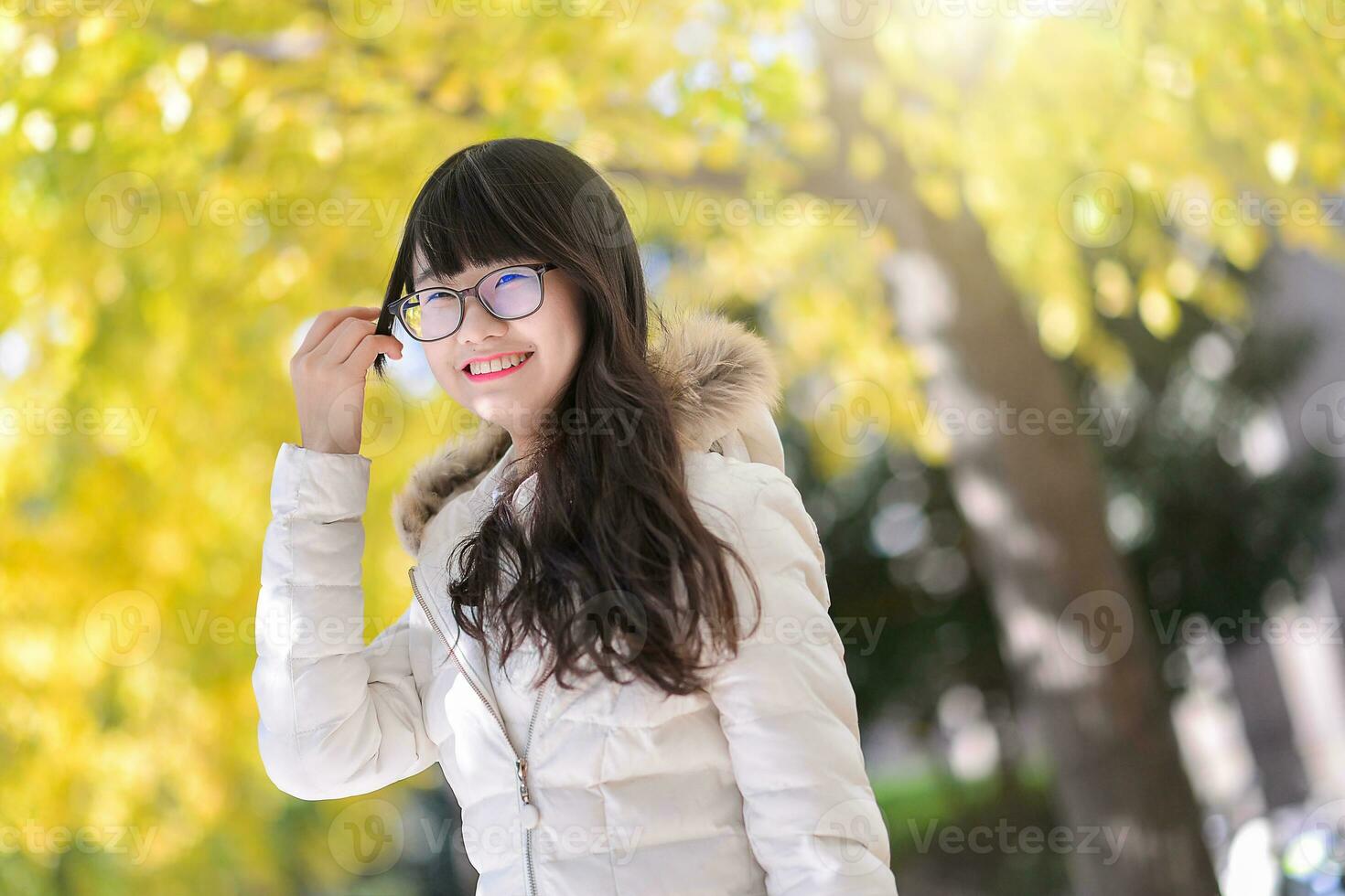 bella Cinese ragazza vestiti giù cappotto nel il luce del sole giorno foto
