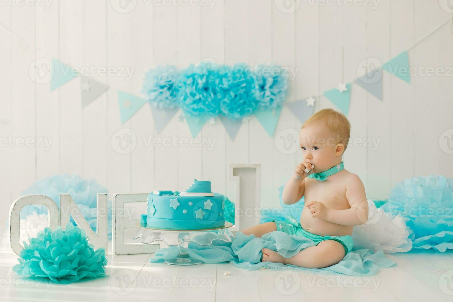 compleanno festa per un' un anno ragazzo nel blu e turchese ghirlande e un' torta, vacanza concetto e arredamento, un' bambino con un' torta foto