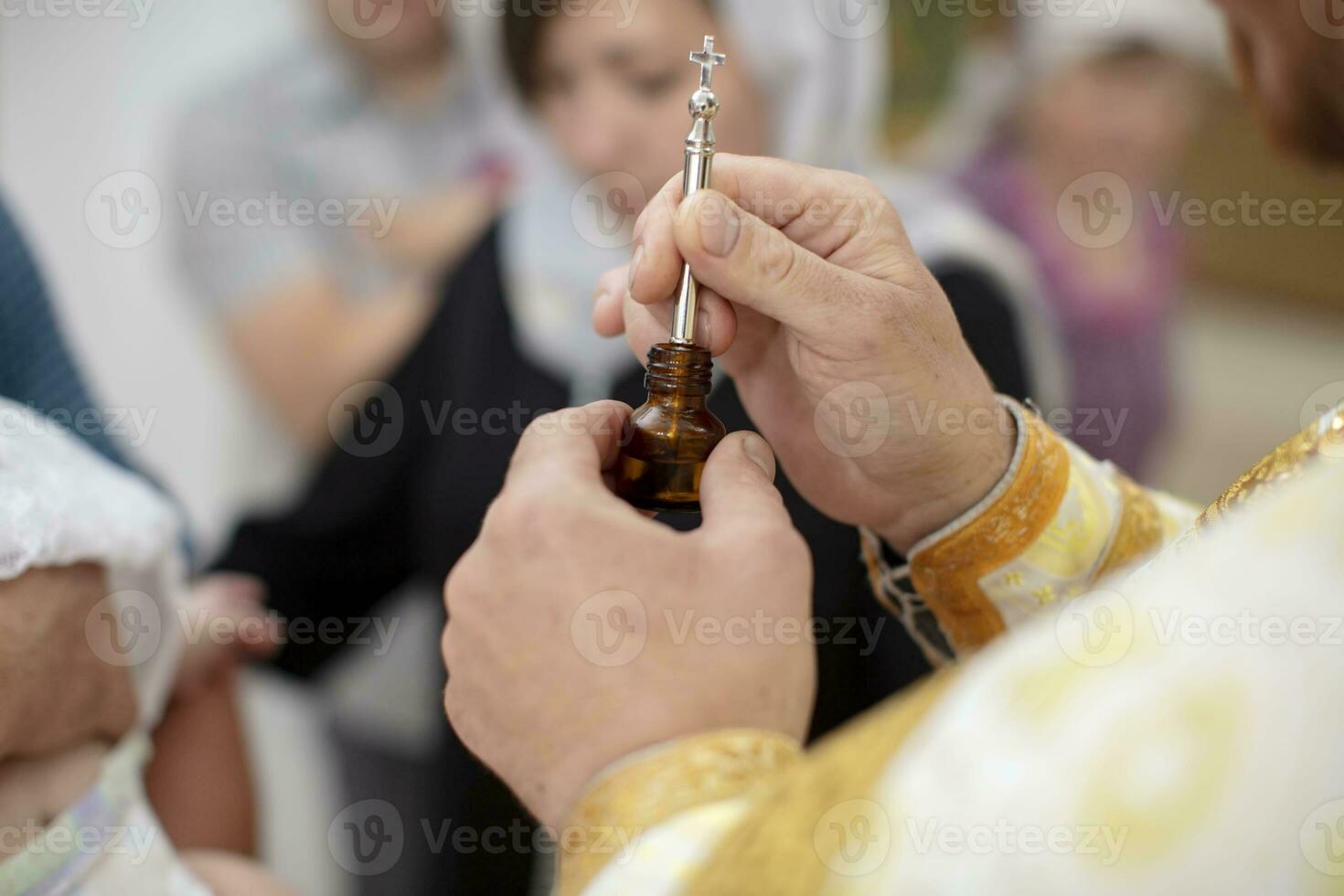 il del prete mani siamo Tenere un' bottiglia di incenso e un' spazzola per battesimo. foto