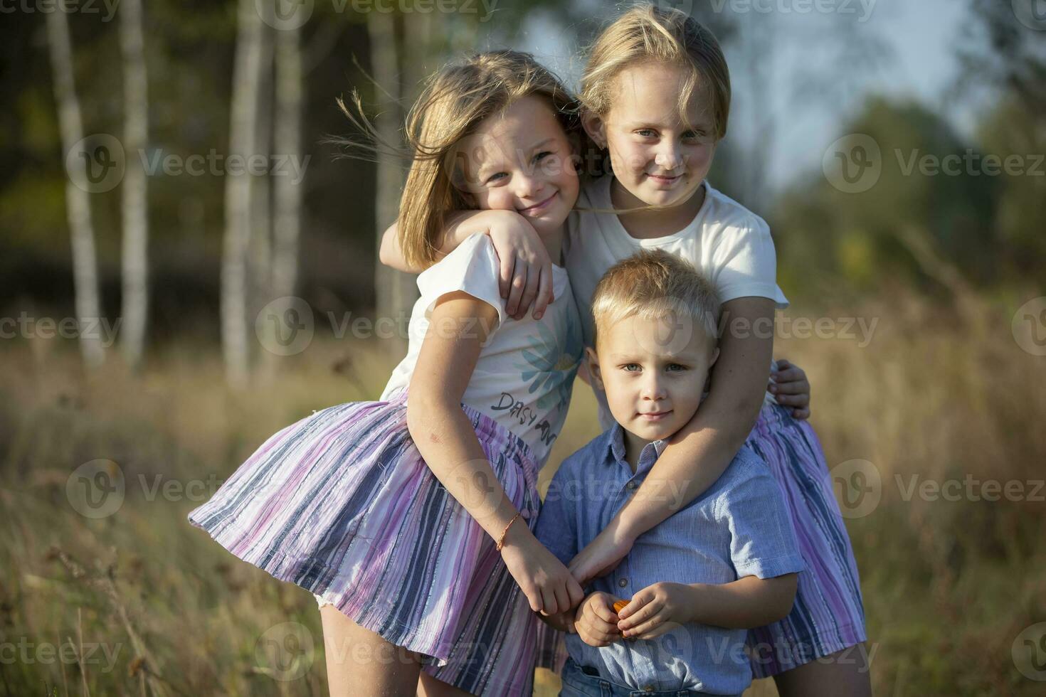 poco fratello e Due sorelle siamo guardare a il telecamera. foto