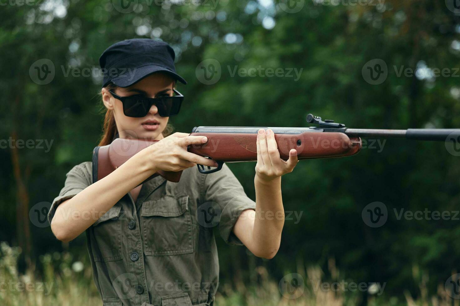 donna soldato arma nel mano a caccia occhiali da sole nero berretto foto