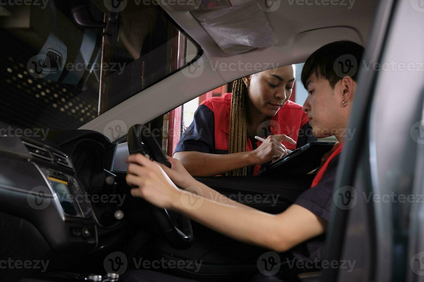 giovane maschio asiatico settore automobilistico meccanico tecnico e compagno controllo Manutenzione elenco con tavoletta nel auto interno a box auto. veicolo servizio fix e riparazione lavori, industriale occupazione attività commerciale lavori. foto