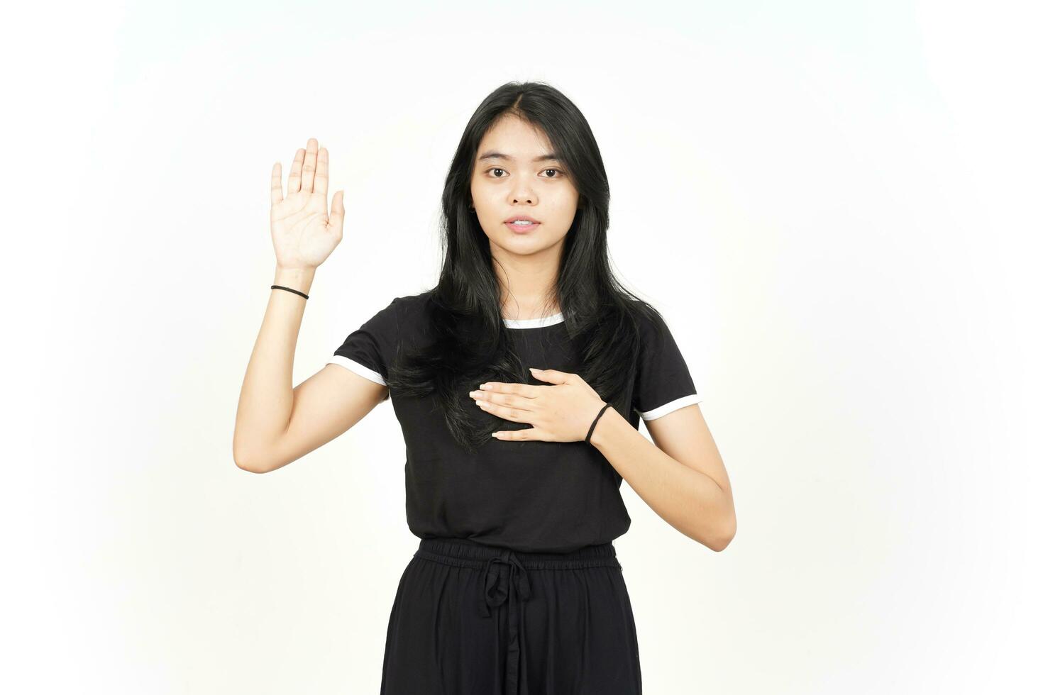 bestemmiare gesto, rendere un giuramento di bellissimo asiatico donna isolato su bianca sfondo foto