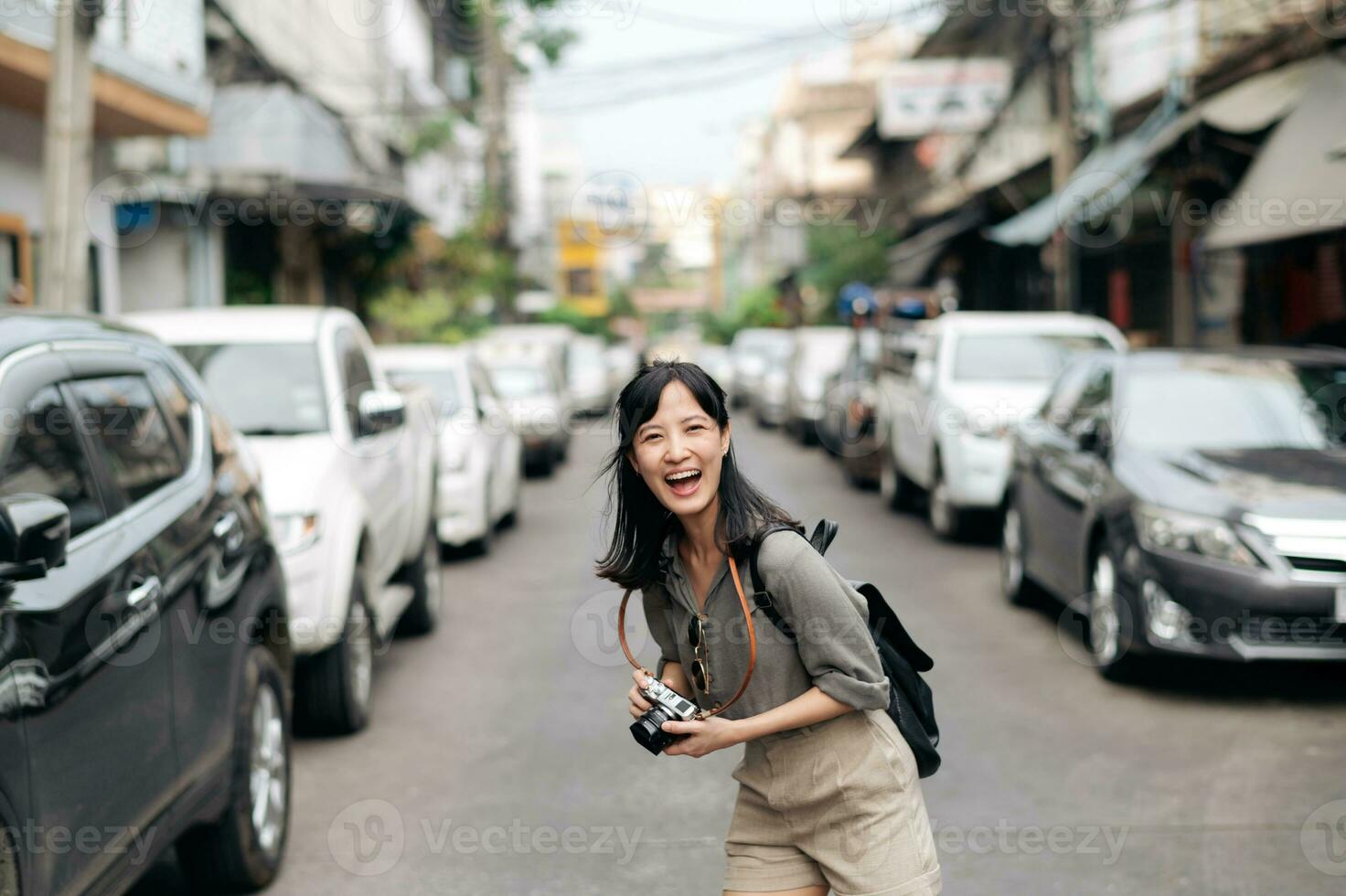 giovane asiatico donna zaino viaggiatore utilizzando digitale compatto telecamera, godendo strada culturale Locale posto e Sorridi. viaggiatore controllo su lato strade. foto