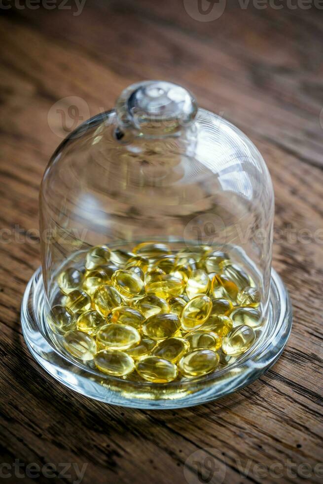 Omega 3 capsule sotto il bicchiere cupola foto