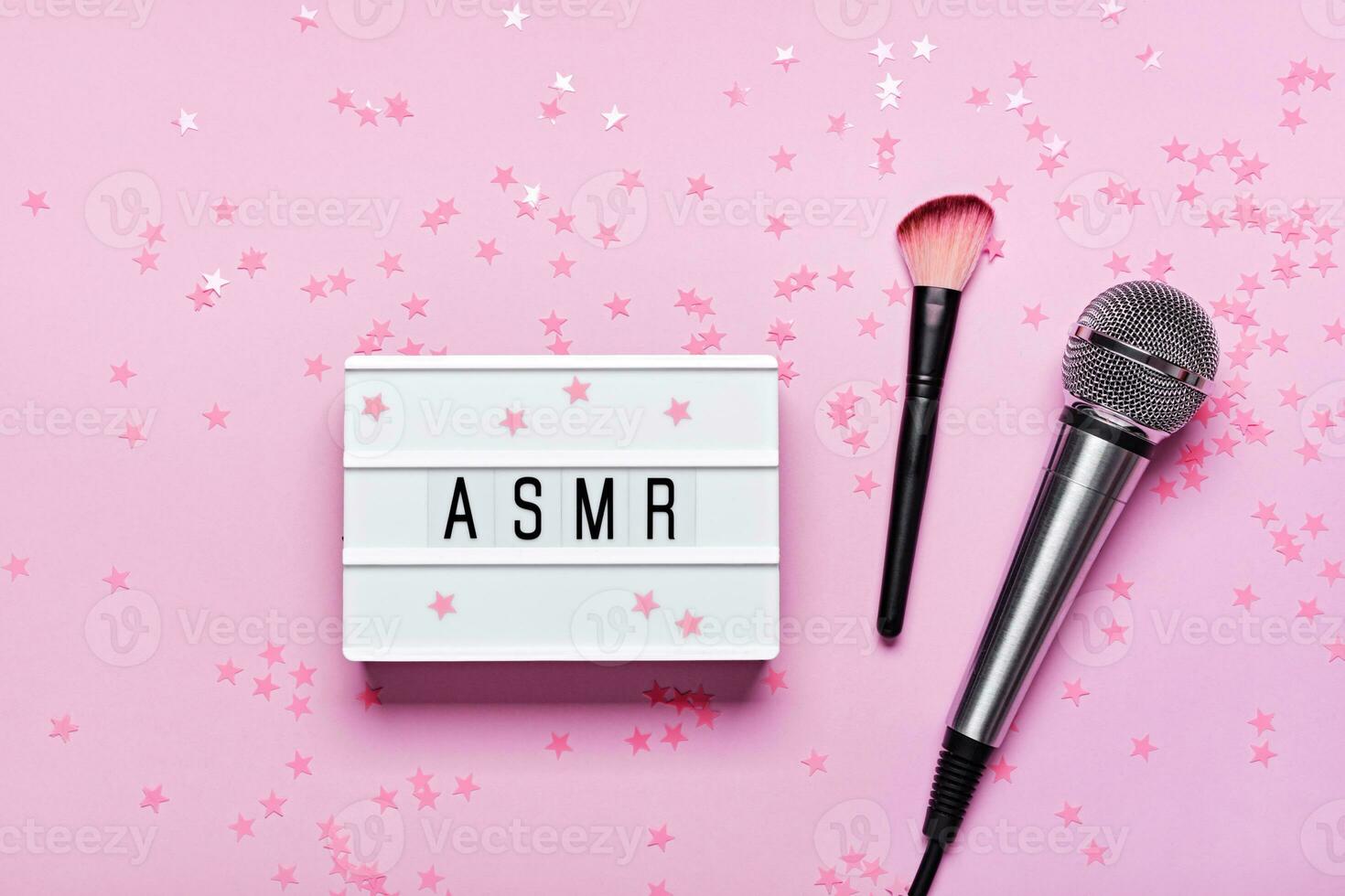 microfono, spazzola e asmr testo lightbox su rosa coriandoli sfondo. asmr registrazione fatica alleviare suoni concetto, piatto posizione, trend ombre foto