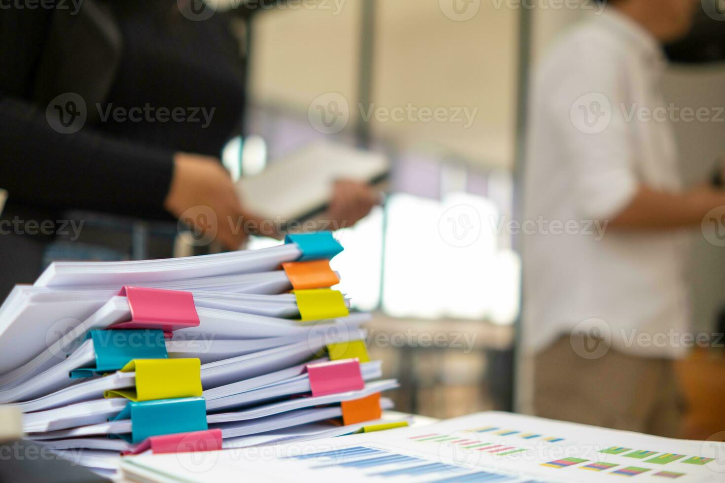 donna d'affari mani Lavorando su pile di carta documenti per ricerca e revisione documenti ammucchiati su tavolo prima invio loro per tavola di registi per uso corretta documenti nel incontro con uomo d'affari foto