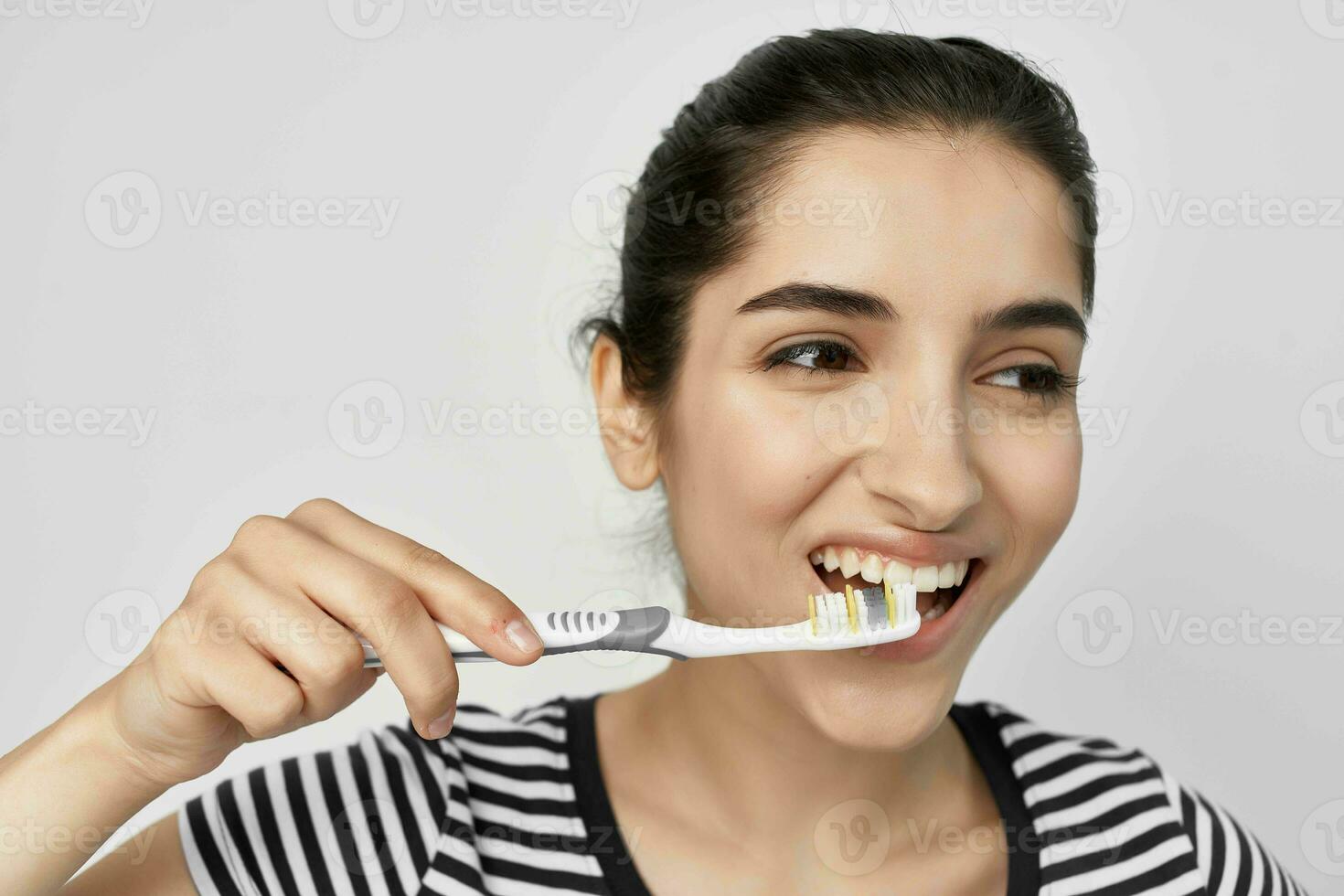 brunetta spazzola il tuo denti con un' spazzolino isolato sfondo foto