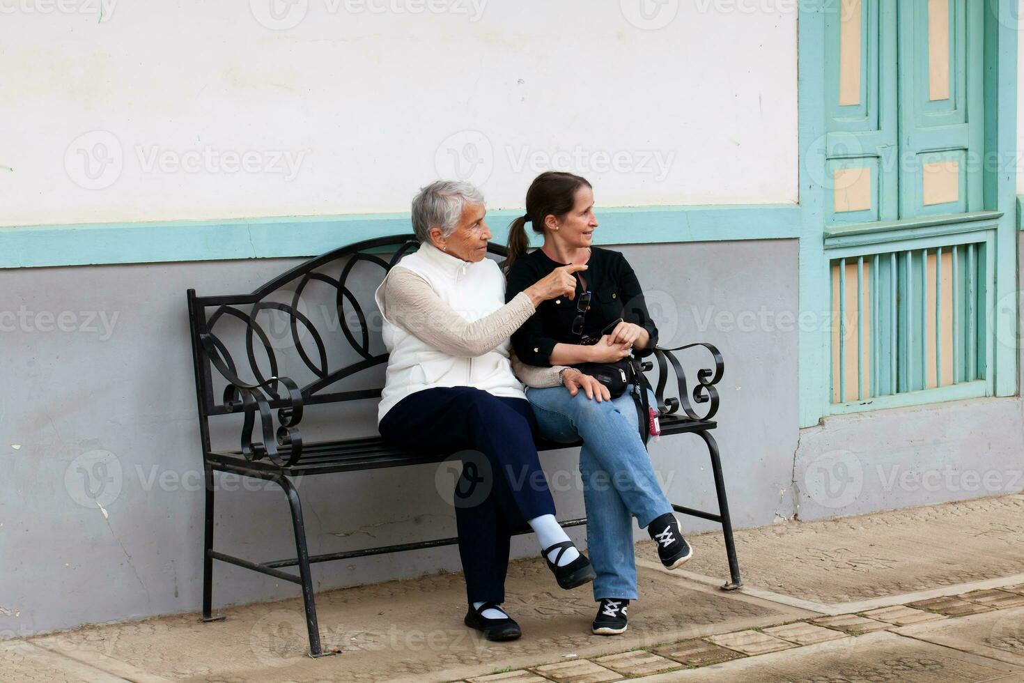 anziano madre e adulto figlia in viaggio insieme a il bellissimo piccolo cittadina di salentino, collocato su il regione di quindio nel Colombia foto