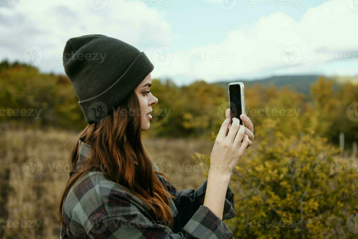 donna con mobile Telefono nel il autunno foresta e montagne nel il sfondo foto