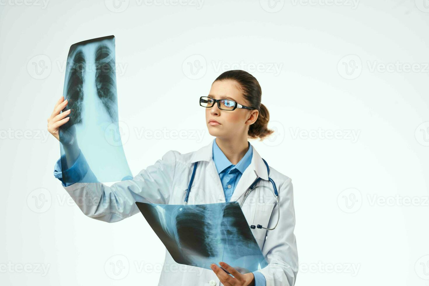 un' radiologo nel un' bianca cappotto esamina raggi x trattamento un' paziente foto