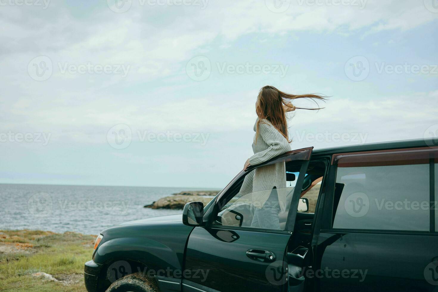 donna con rosso capelli nel un' maglione vicino il auto natura femmina rilassante foto