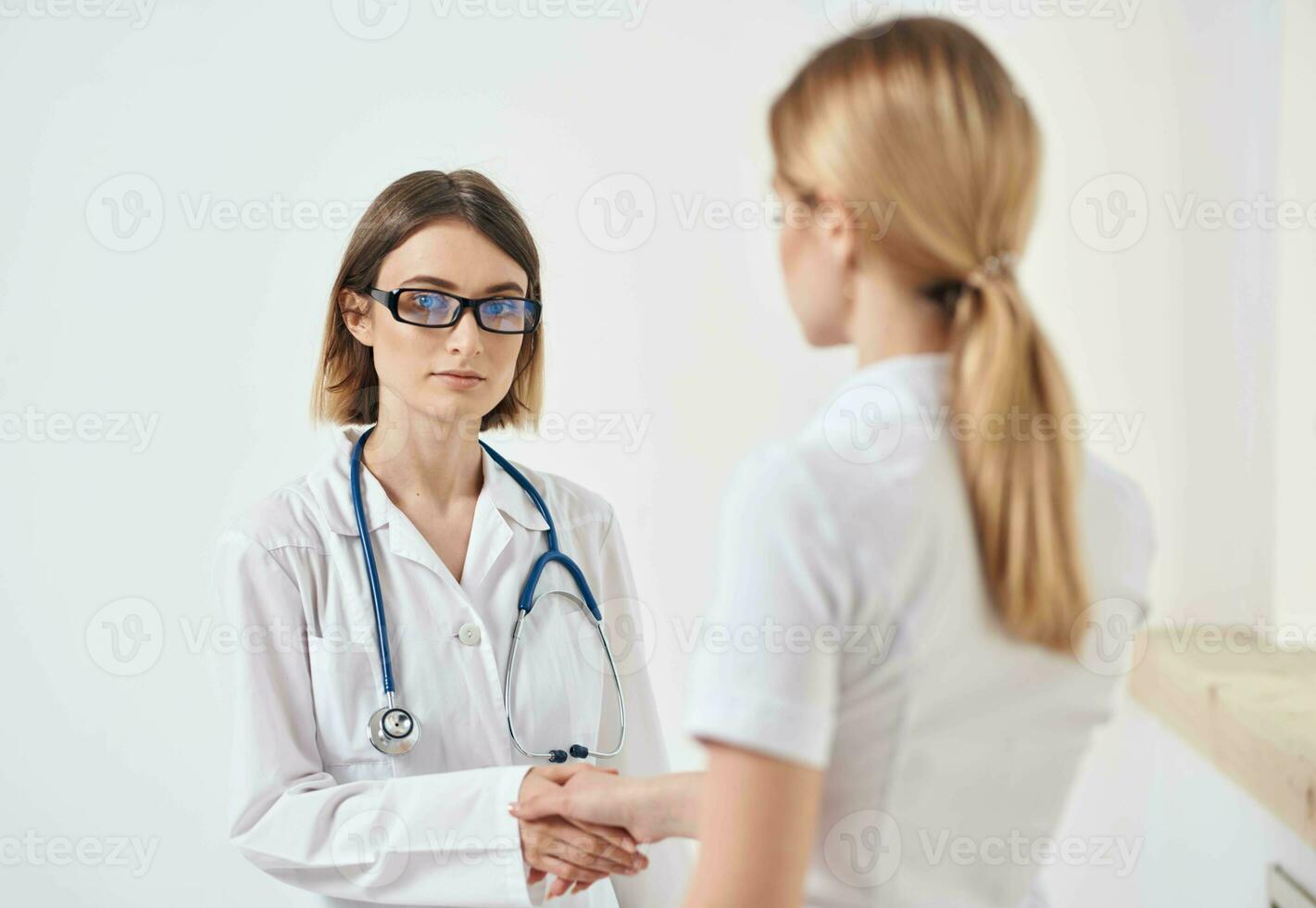 medico nel un' medico toga con un' stetoscopio e un' paziente nel un' bianca maglietta indietro Visualizza foto
